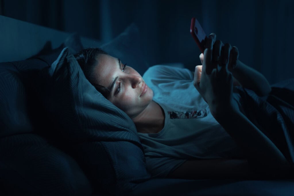 A girl on her phone late at night.